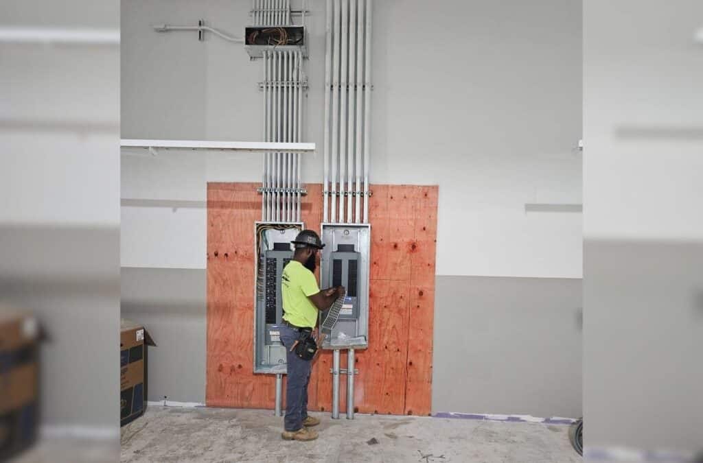 Technician assessing coordinated building systems with detailed plans and diagnostic tools onsite